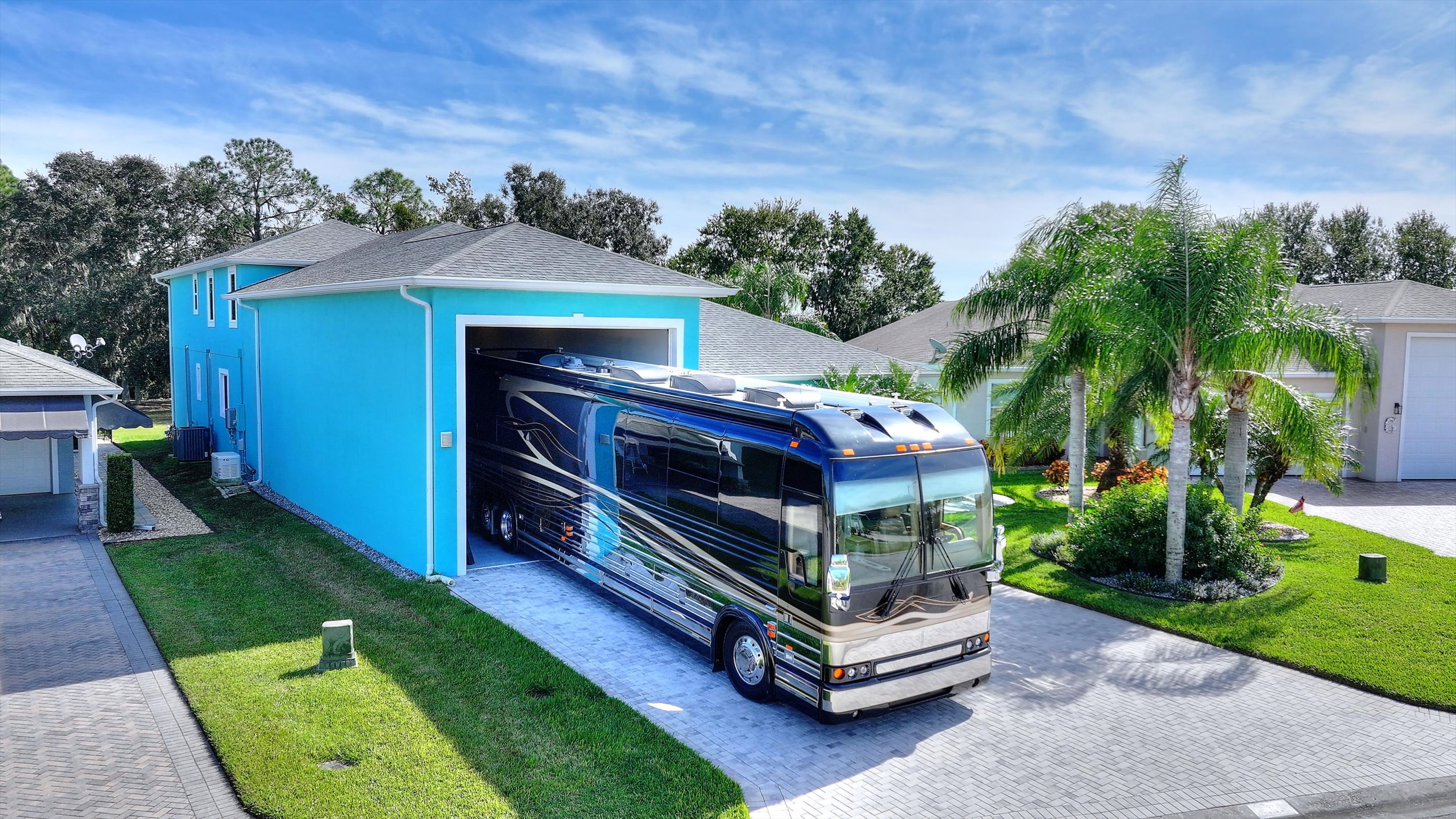 Garage exterior with RV and boat in driveway — aerial view