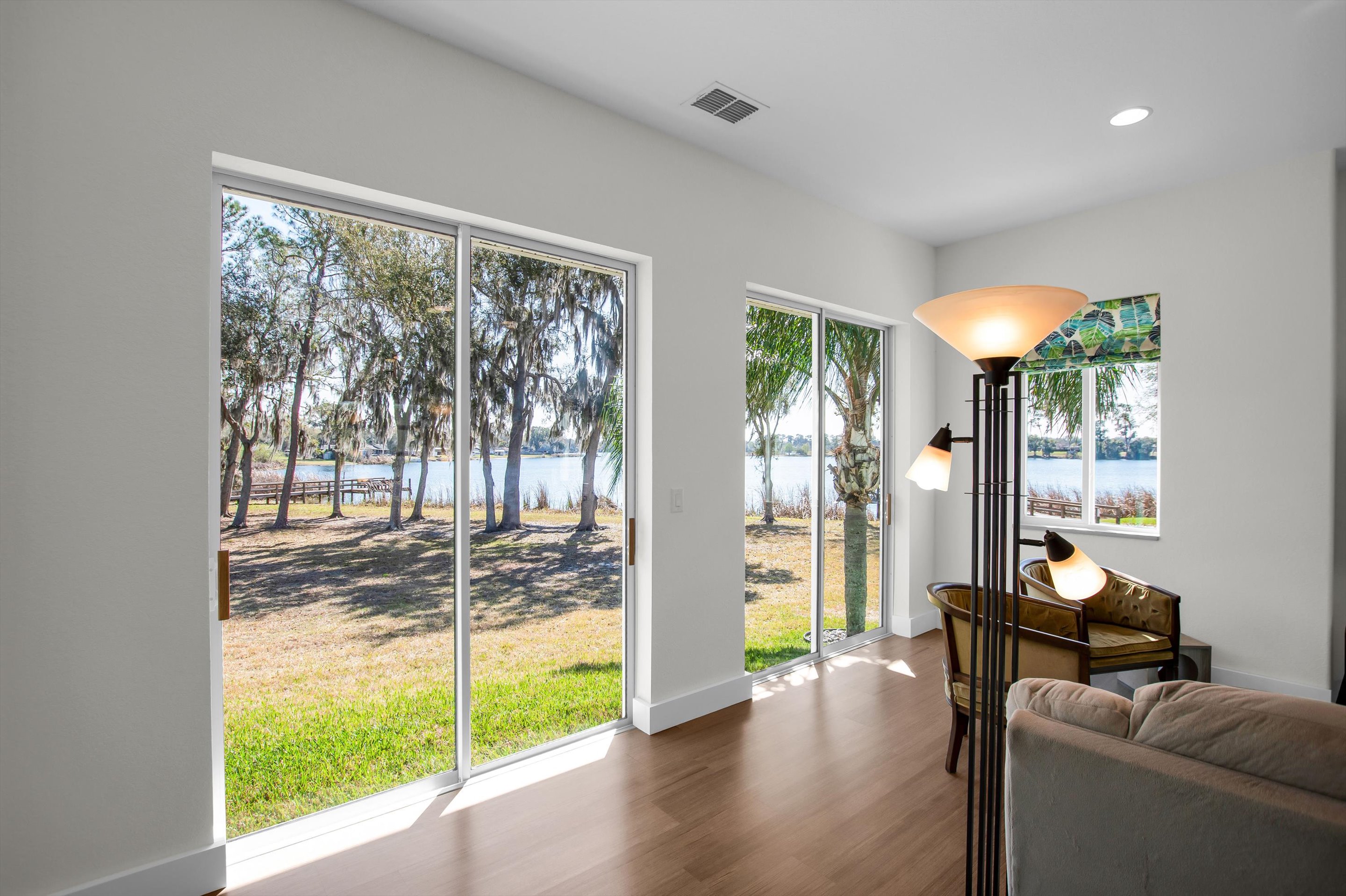 Living room view through floor-to-ceiling sliders towards the private lake